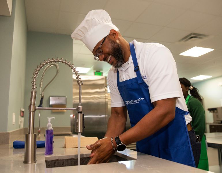 028880.jpg Andrá Johnson washing his hands before a cooking demonstration at the Alachua County Extension Office. Photo taken 05-01-23