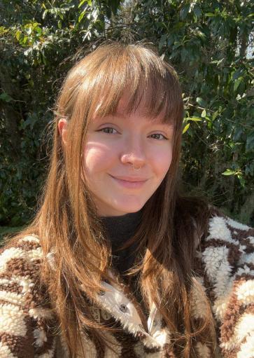 Photo of Hannah standing in front of trees