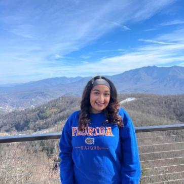Rameen standing in front of mountains, smiling into camera