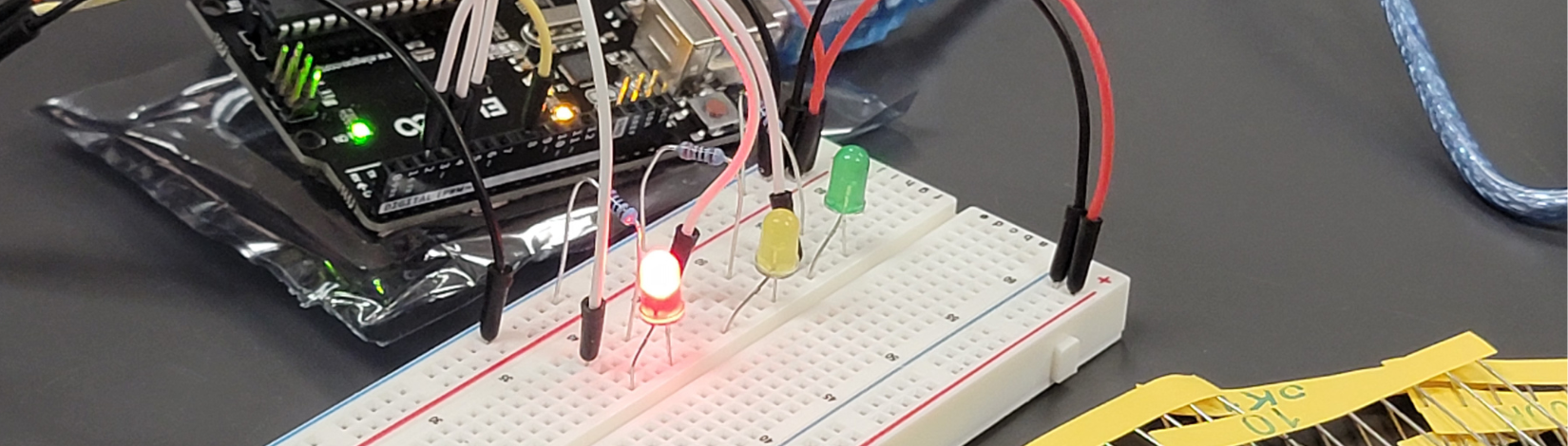 Close-up of a breadboard circuit with LED lights connected to a microcontroller during a hands-on AgTech electronics activity