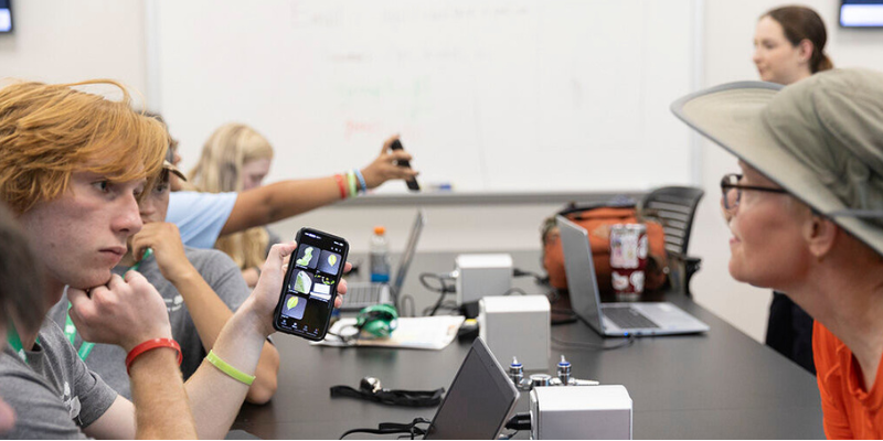 Youth participants exploring digital tools for plant science learning in a classroom setting