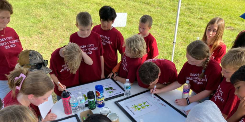 Students engaged in a hands-on AgTech learning station using the 4-H experiential learning model.