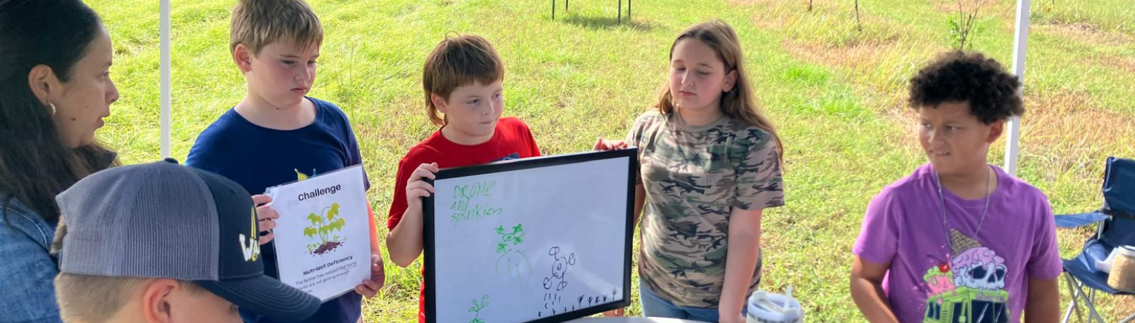 Youth participants presenting their agriculture challenge solution during the Ag Tech Station activity at the UF/IFAS Ag Adventures event.